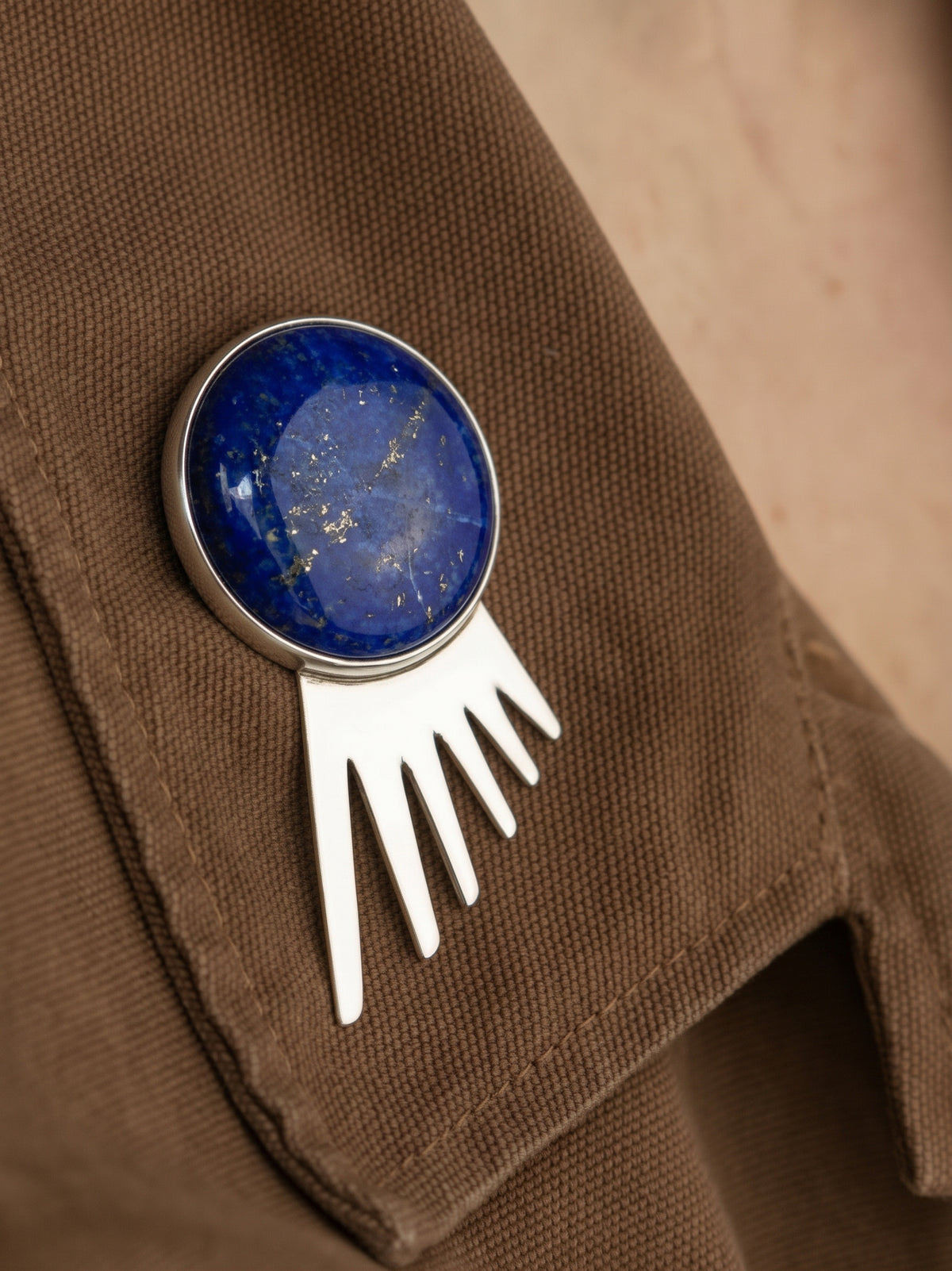 Sol Spur Pin Grande in sterling silver with lapis lazuli, worn on the model — handmade in Taxco, Mexico #Gemstone Type_Lapis lazuli